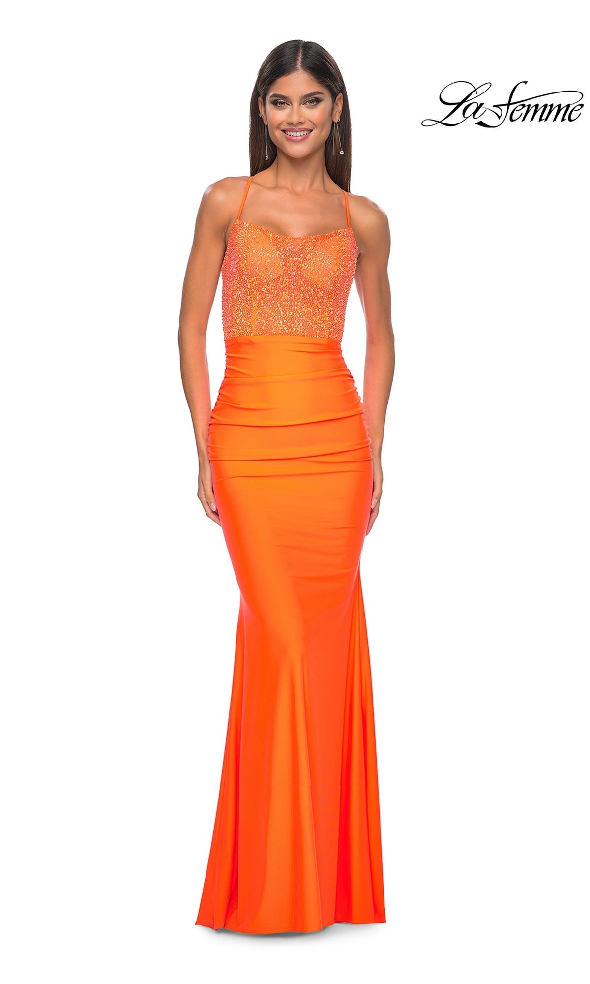 A woman wearing the La Femme Backless Bright Long Prom Dress 32325, a sleeveless orange beaded formal gown featuring a fitted bodice and smooth, floor-length flared skirt.
